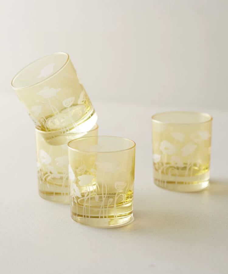 Drinking glasses decorated with painted yellow poppy flowers.