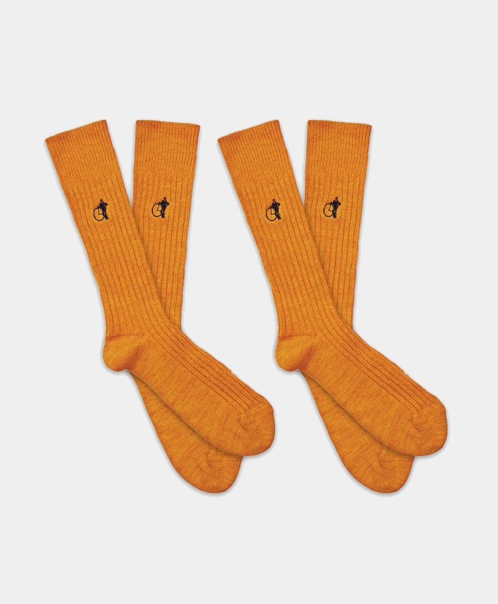 Four pairs of orange ribbed knee-high socks with small embroidered bicycle logos.