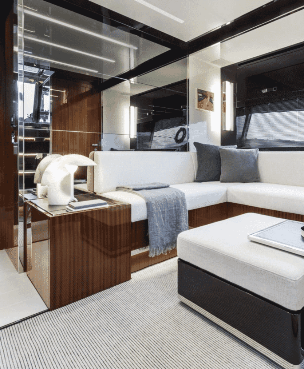 Luxury yacht interior featuring white sectional sofas, mirrored surfaces, and high-gloss mahogany