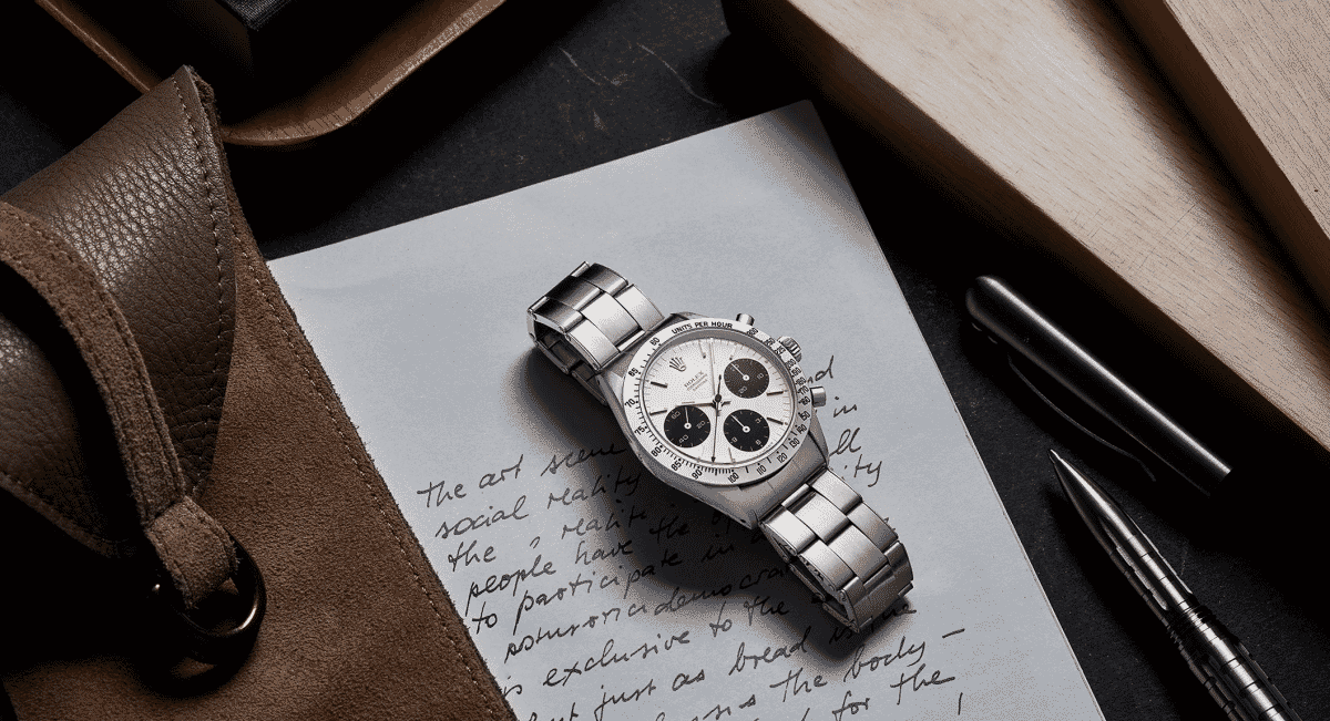 A silver Rolex chronograph resting on handwritten notes, signifying the end of the collector's journey.