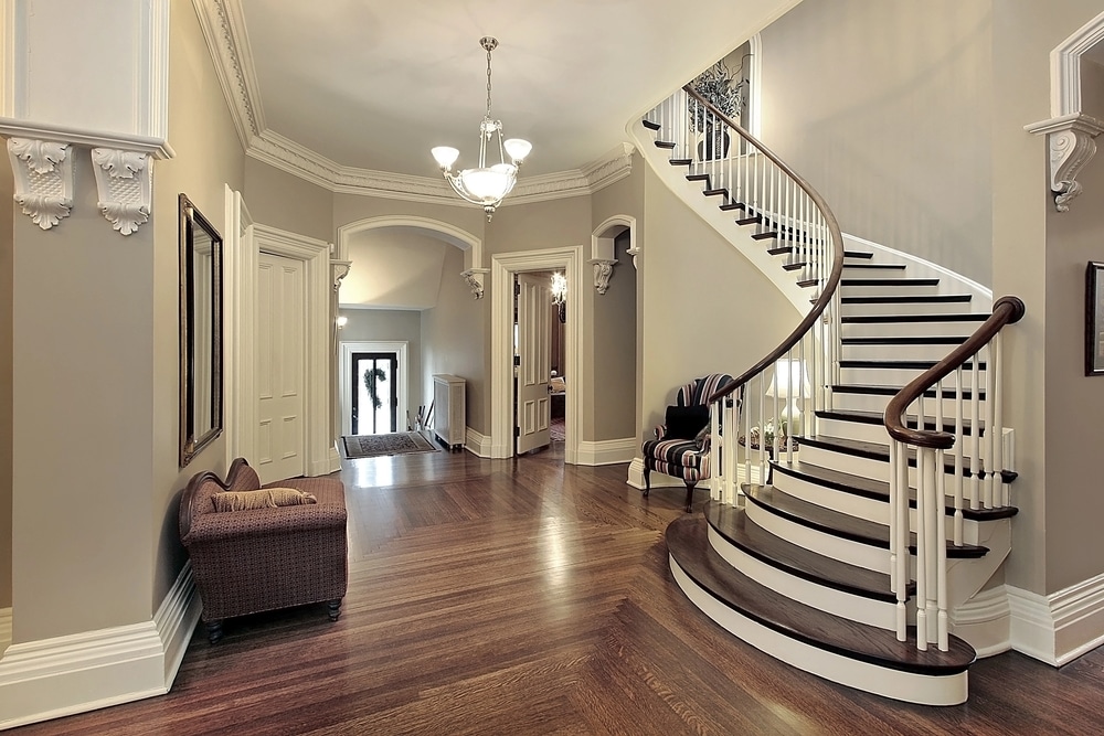 Elegant interior hallway featuring a grand curved staircase and classic hardwood floors.