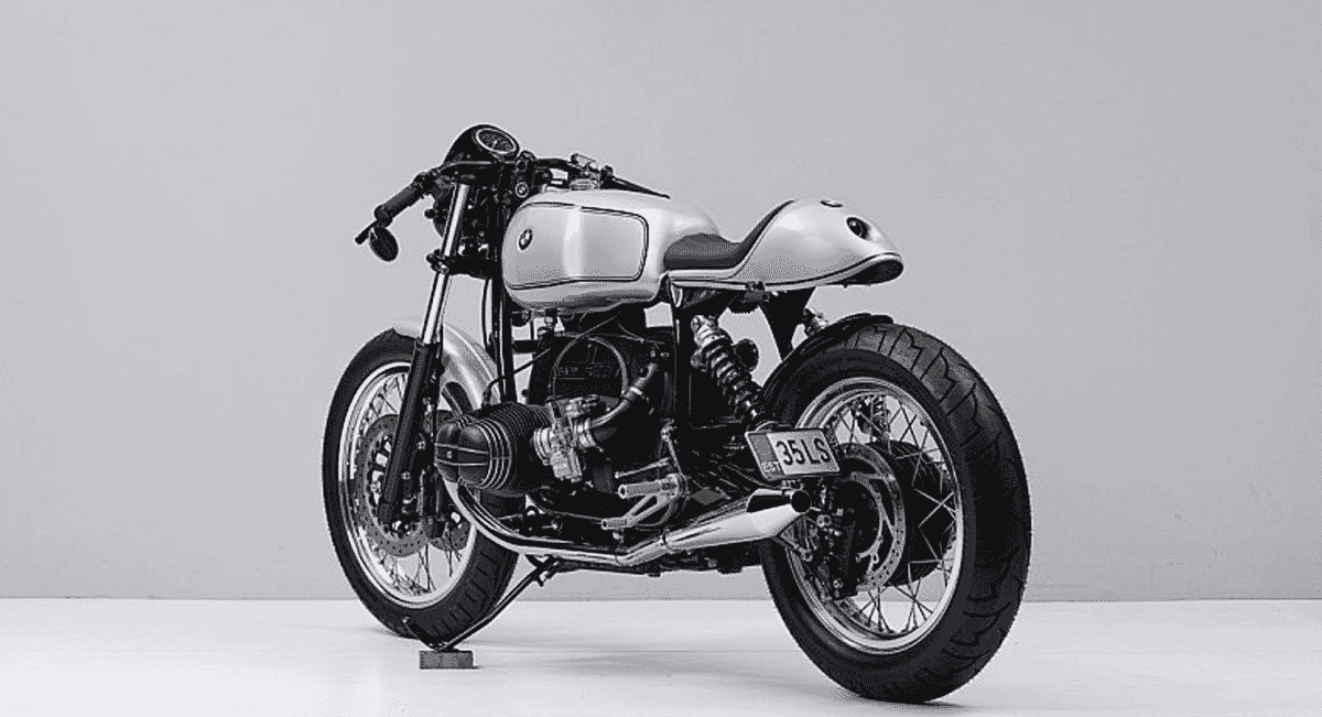 Silver BMW café racer with an exposed boxer engine in a studio setting.