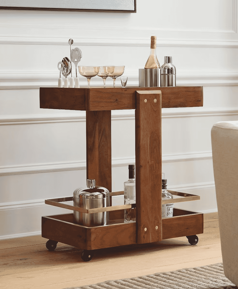 A rustic wooden bar cart with metal accents holding cocktail glasses and bottles in a modern room.