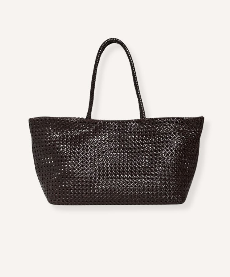 A large tote bag made from woven cane material with leather straps.