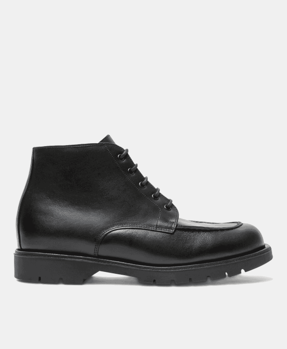 Profile shot of a sleek black leather ankle boot with laces and a thin rugged sole.