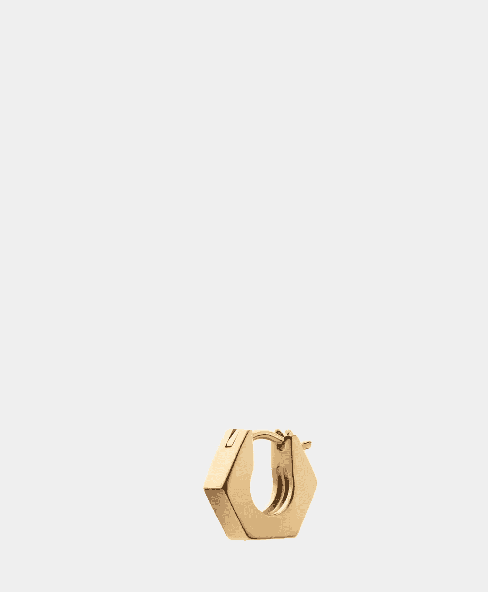 A gold hexagonal hoop earring with a modern geometric silhouette against a white background.