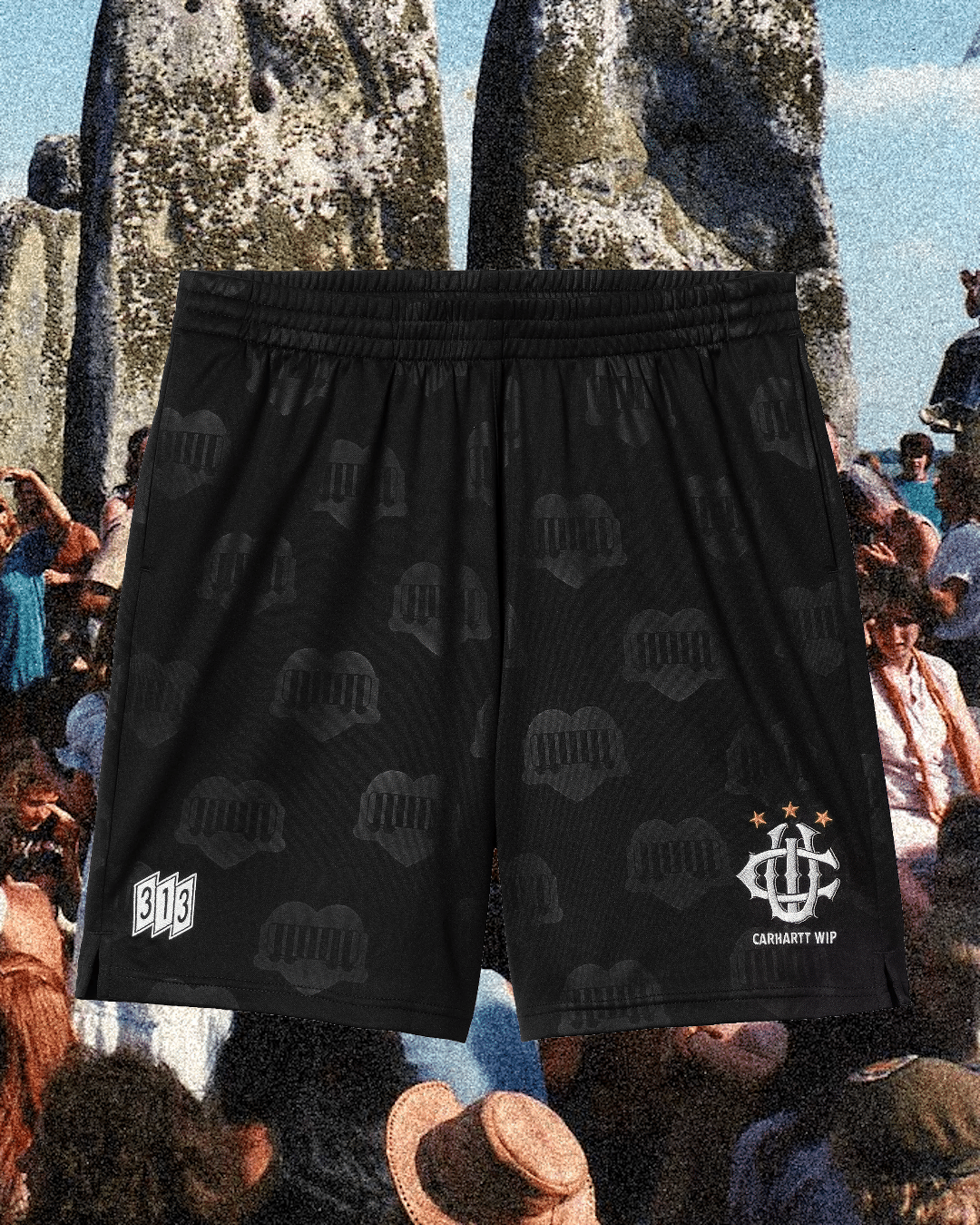 Black athletic shorts with white heart patterns and Carhartt WIP branding shown over a vintage crowd collage.