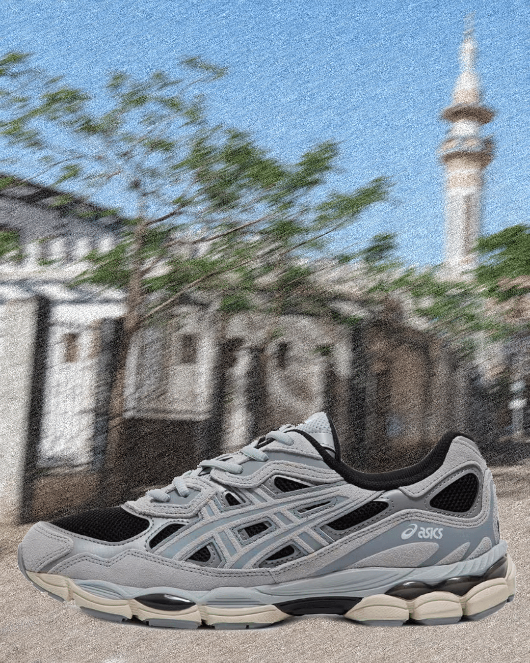 Gray and black Asics sneaker with a thick sole and mesh panels.