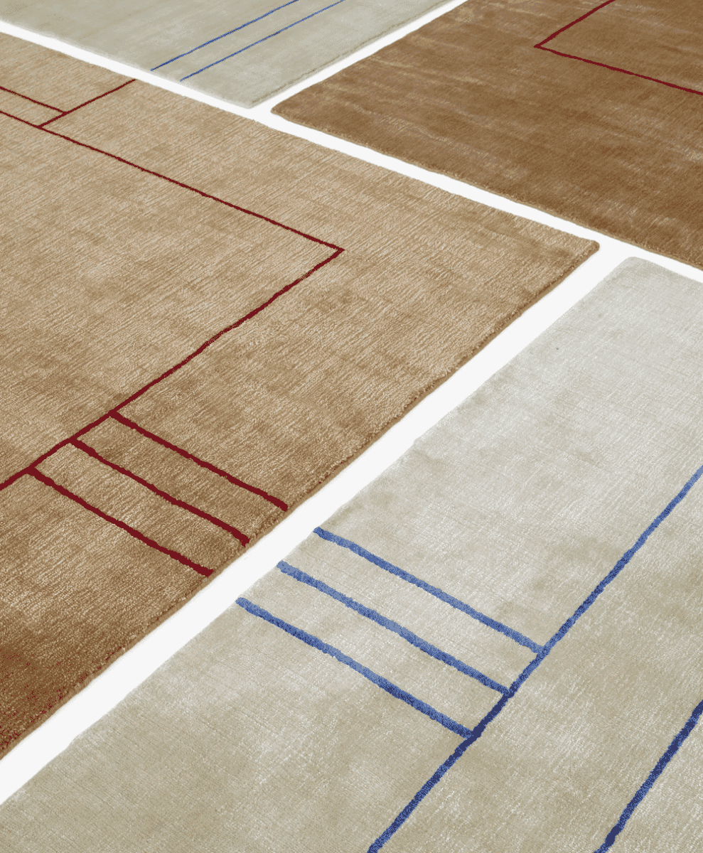 Multiple geometric rugs in neutral tones overlapping to create a layered design.