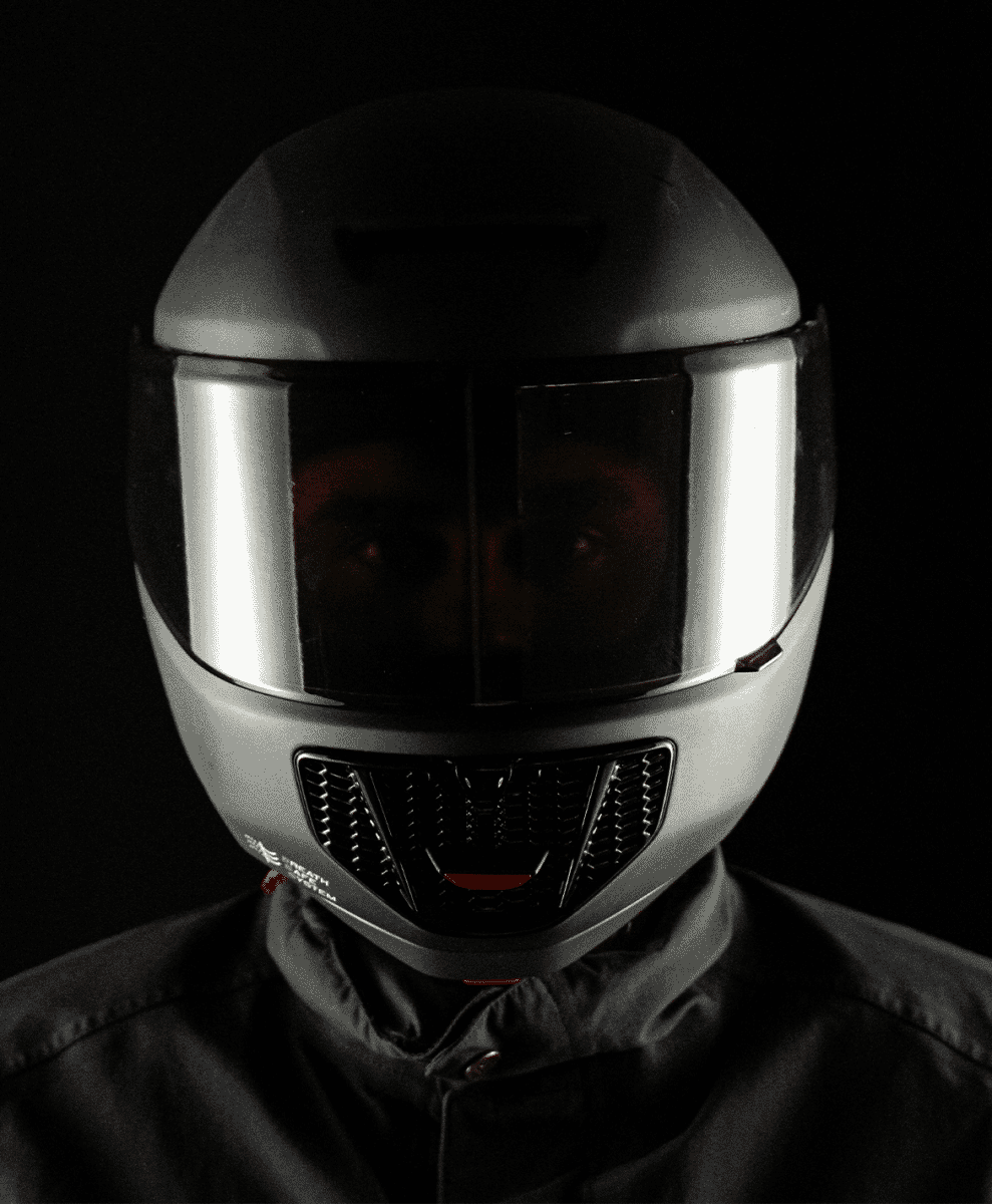 Close-up of a silver full-face helmet with a reflective visor and black air-intake grille.