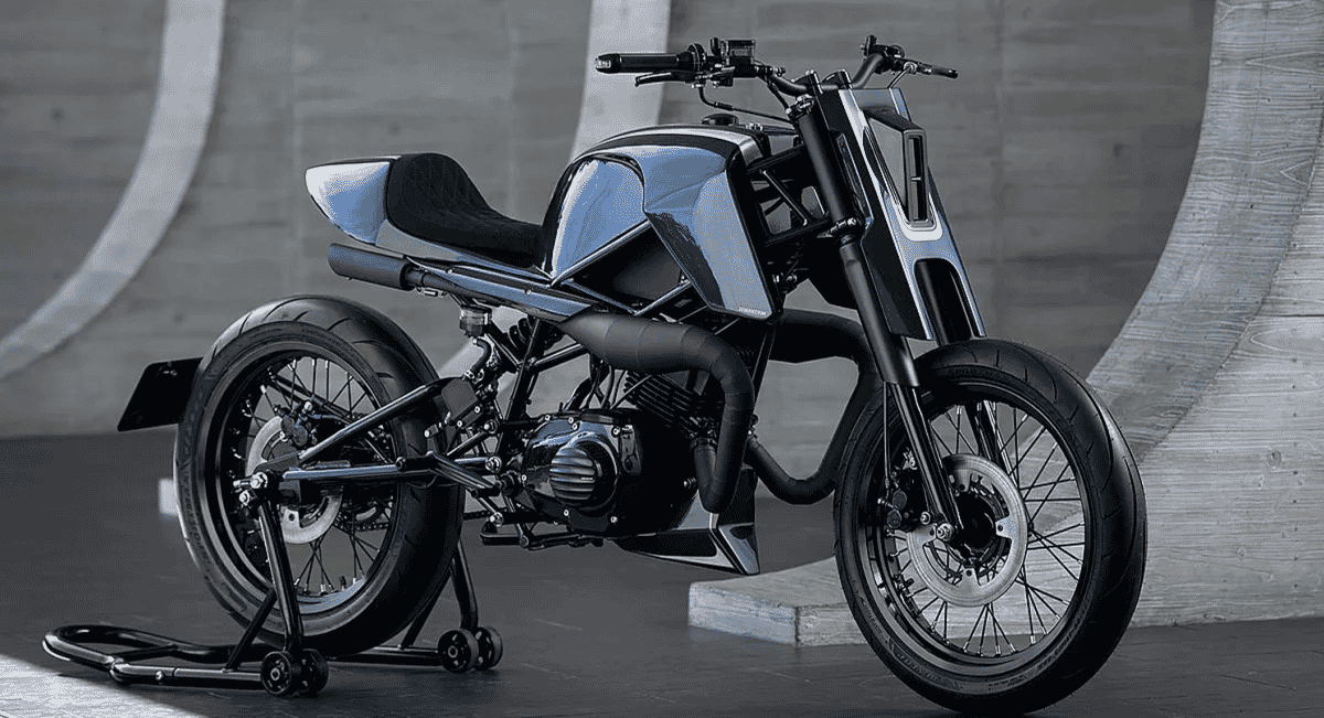 Sleek black custom motorcycle in a studio setting with a concrete backdrop.