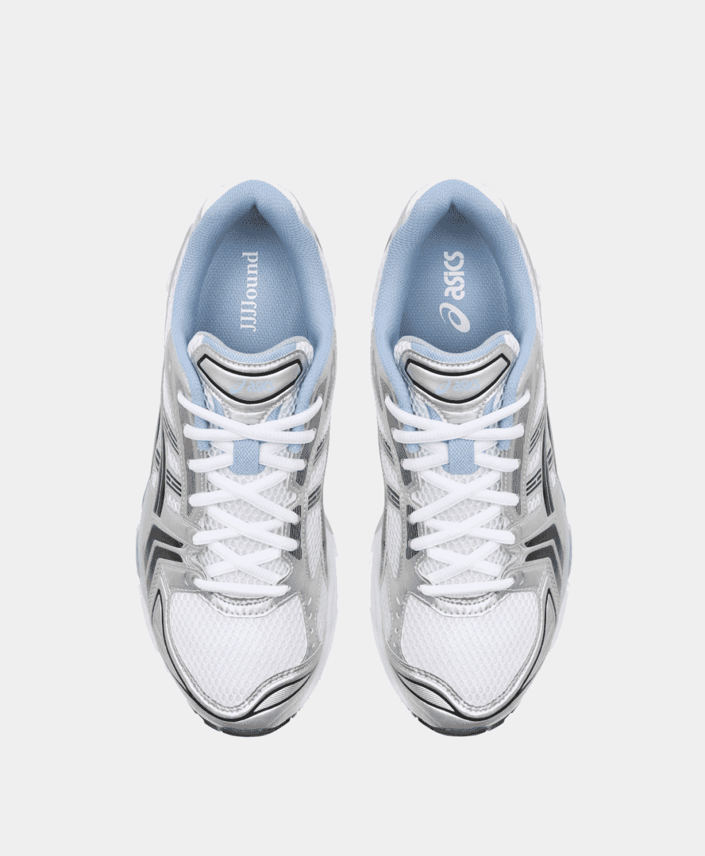 Top-down view of the sneaker tongue labels featuring 'JJJJound' and 'ASICS' branding.