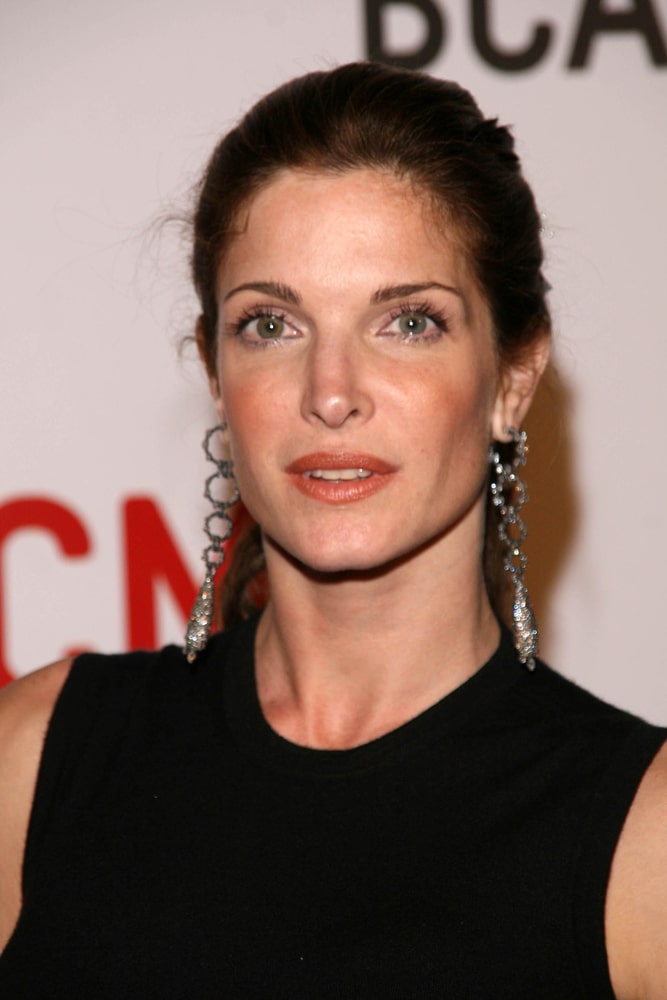 Linda Evangelista wearing a black sleeveless top and elegant dangling earrings.