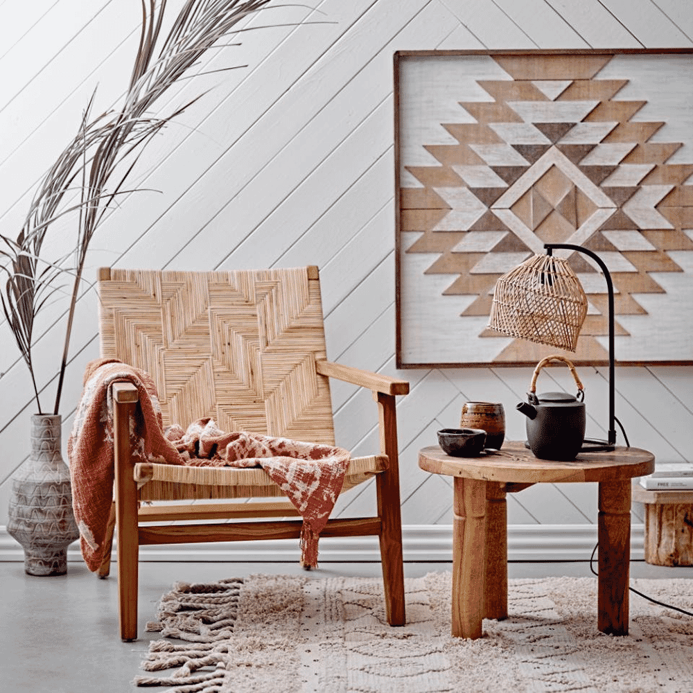A bohemian living room featuring a woven rattan chair and natural textiles.