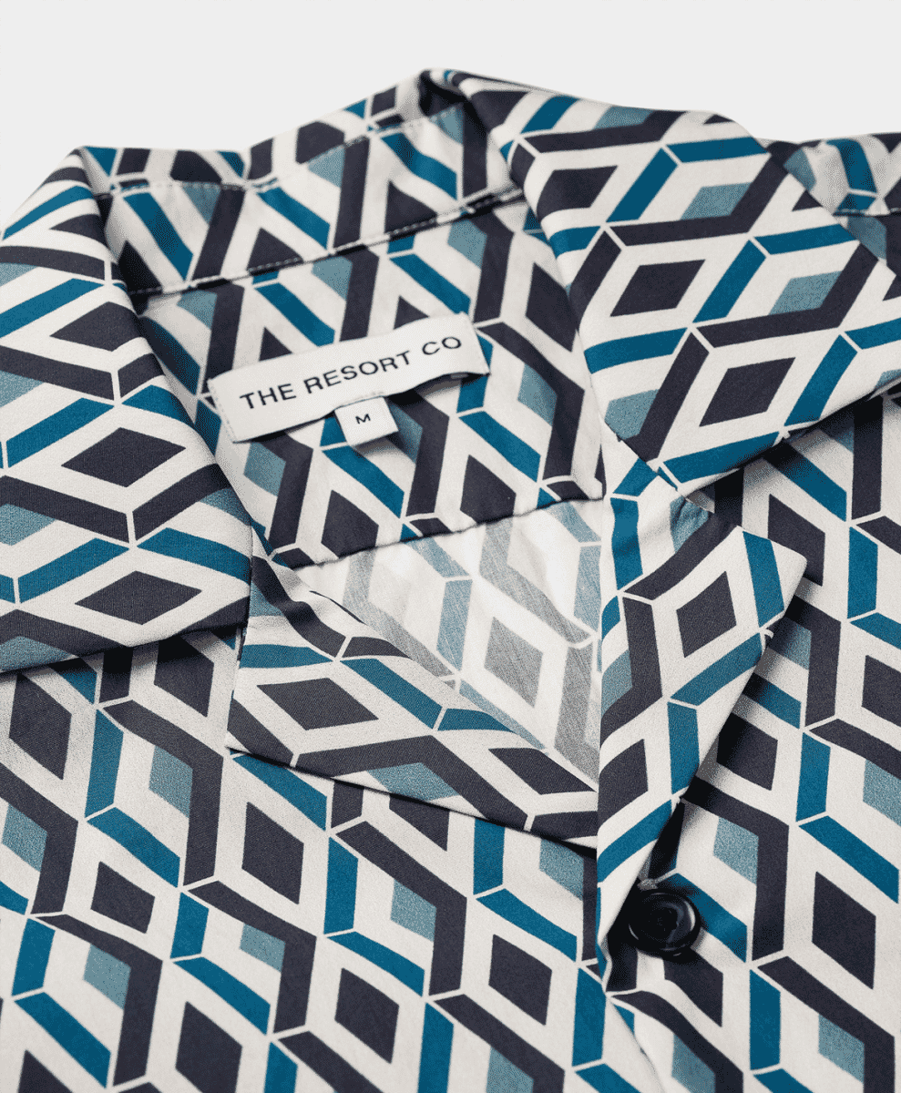 Close-up of The Resort Co resort shirt with navy and white geometric prints.