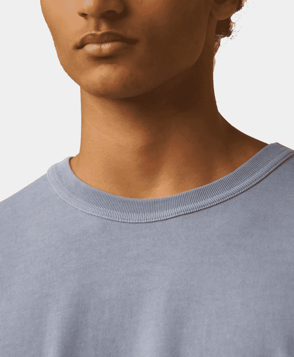 Close-up of the neckline and ribbed texture of a light blue premium cotton t-shirt.