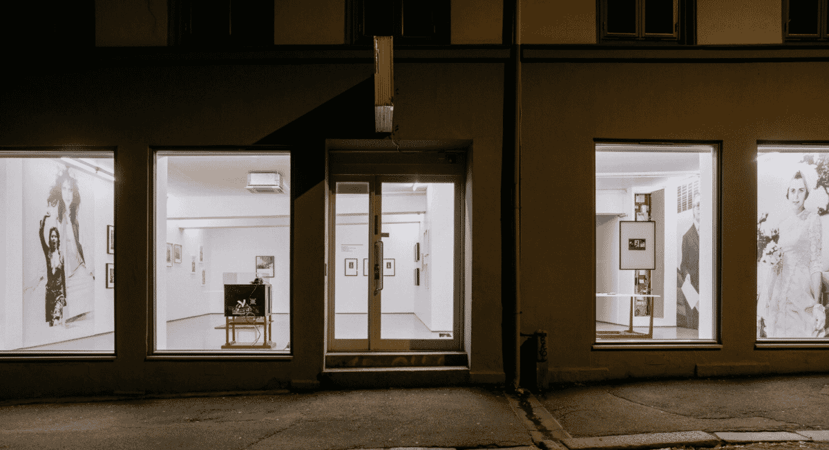 A night view of a photography gallery with black-and-white portraits.