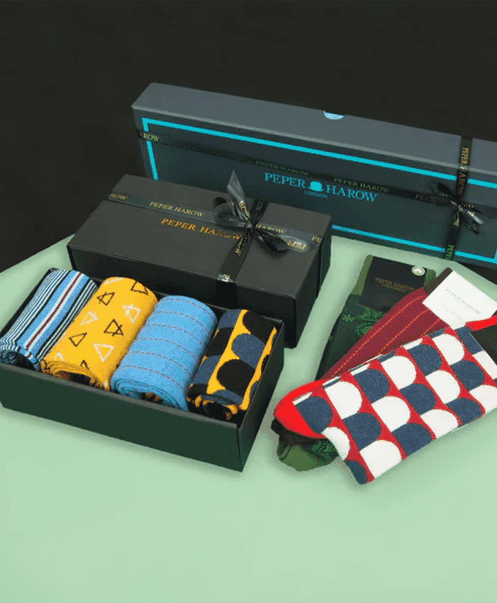 Peper Harow gift boxes in black with ribbons featuring geometric and striped sock designs.