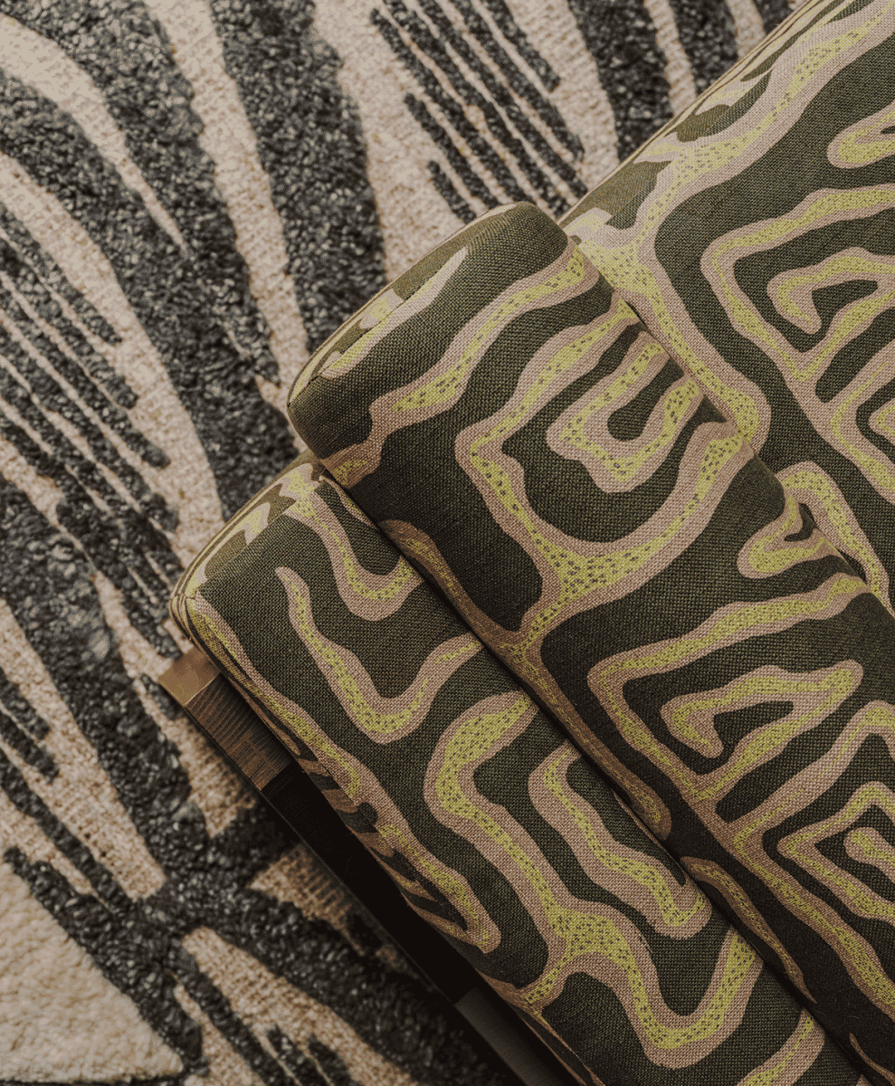 Close-up of rolled fabric samples with abstract wavy patterns in olive green, beige, and lime.