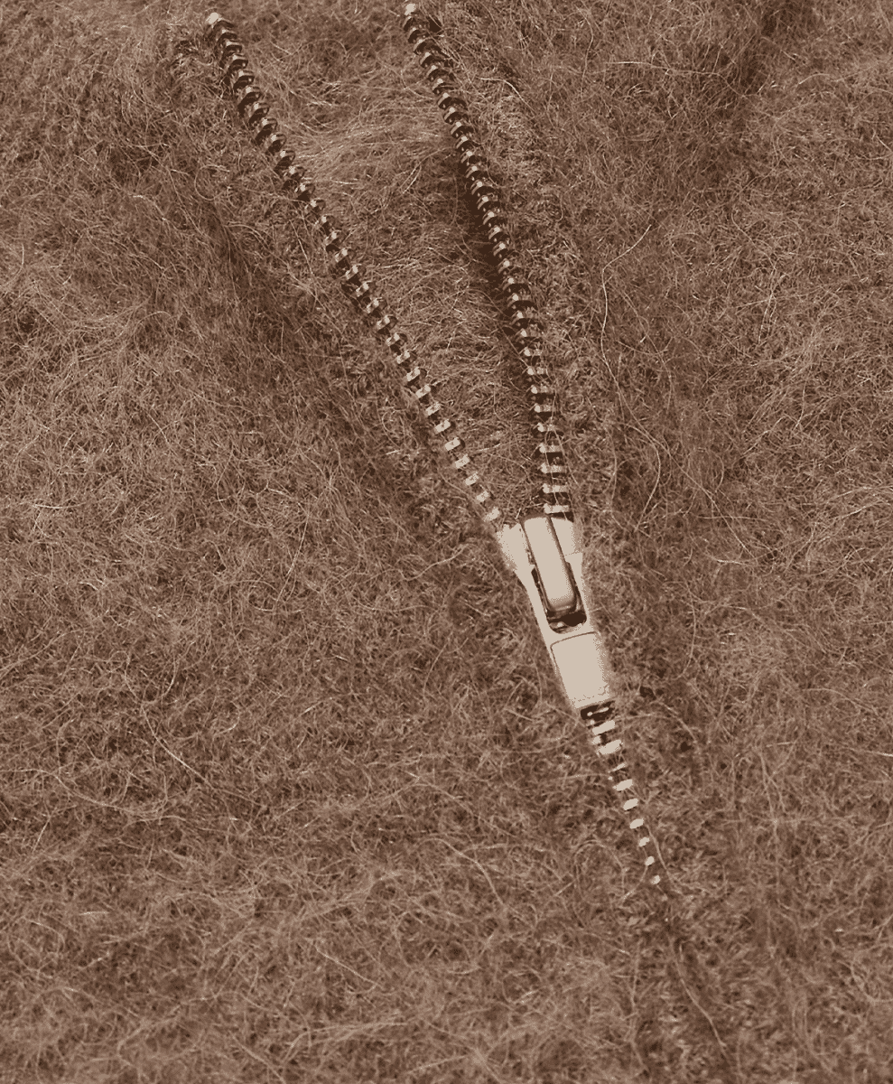 Close-up of brown alpaca-blend wool cardigan with a metal zipper.