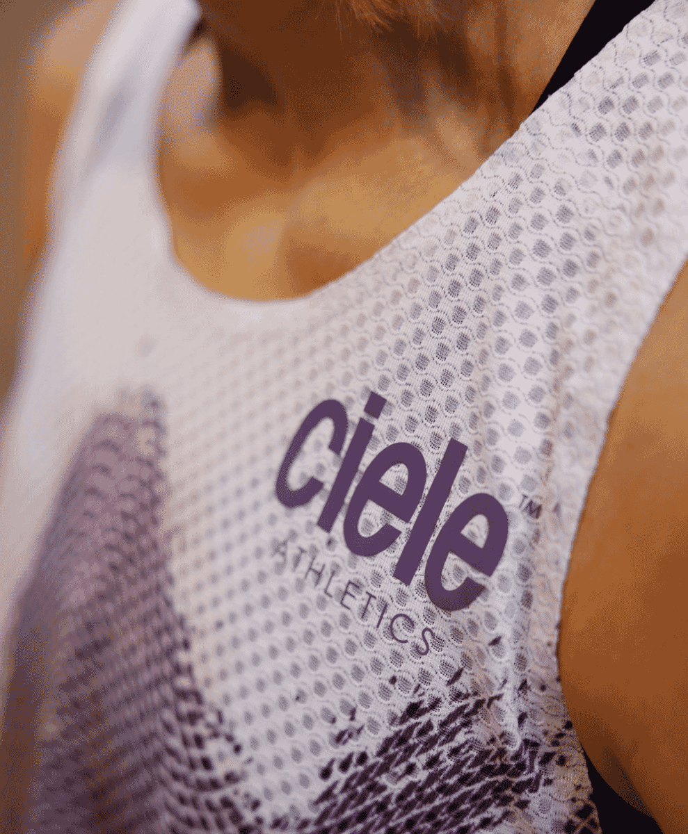 Close-up of a white mesh athletic tank top with the Ciele Athletics logo.