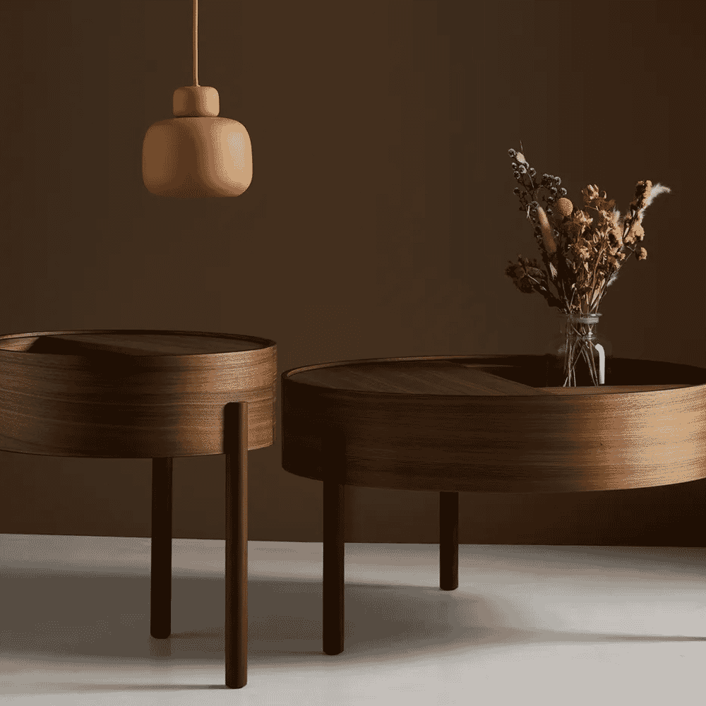 Modern minimalist wooden coffee tables with visible grain and dried floral arrangements.