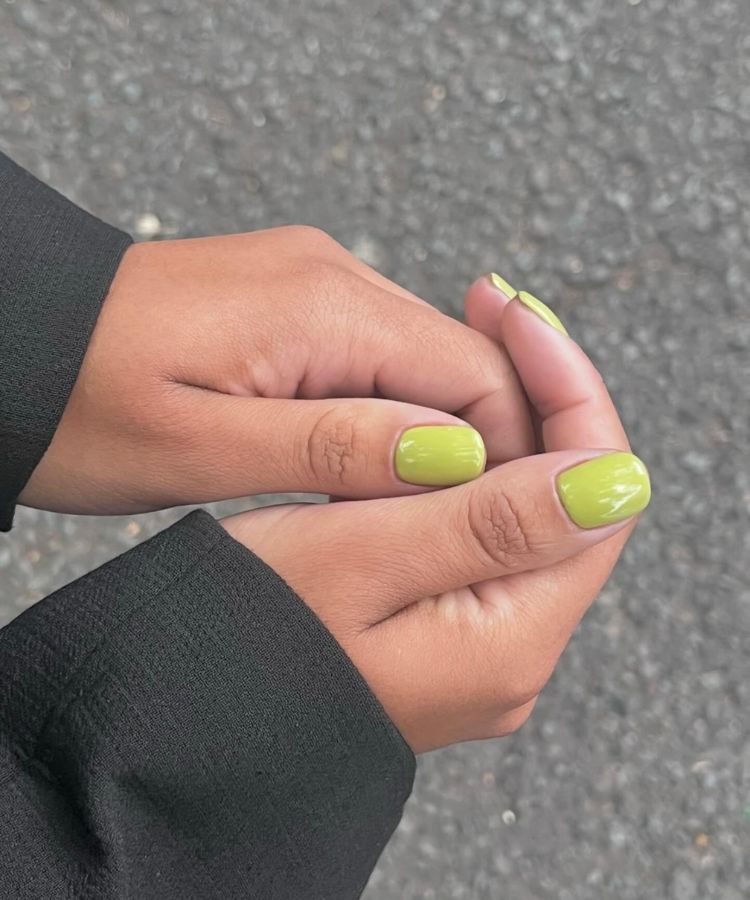 Vibrant lime green manicure on long nails.