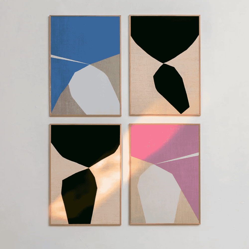 Four framed abstract art prints with geometric shapes on a white wall.
