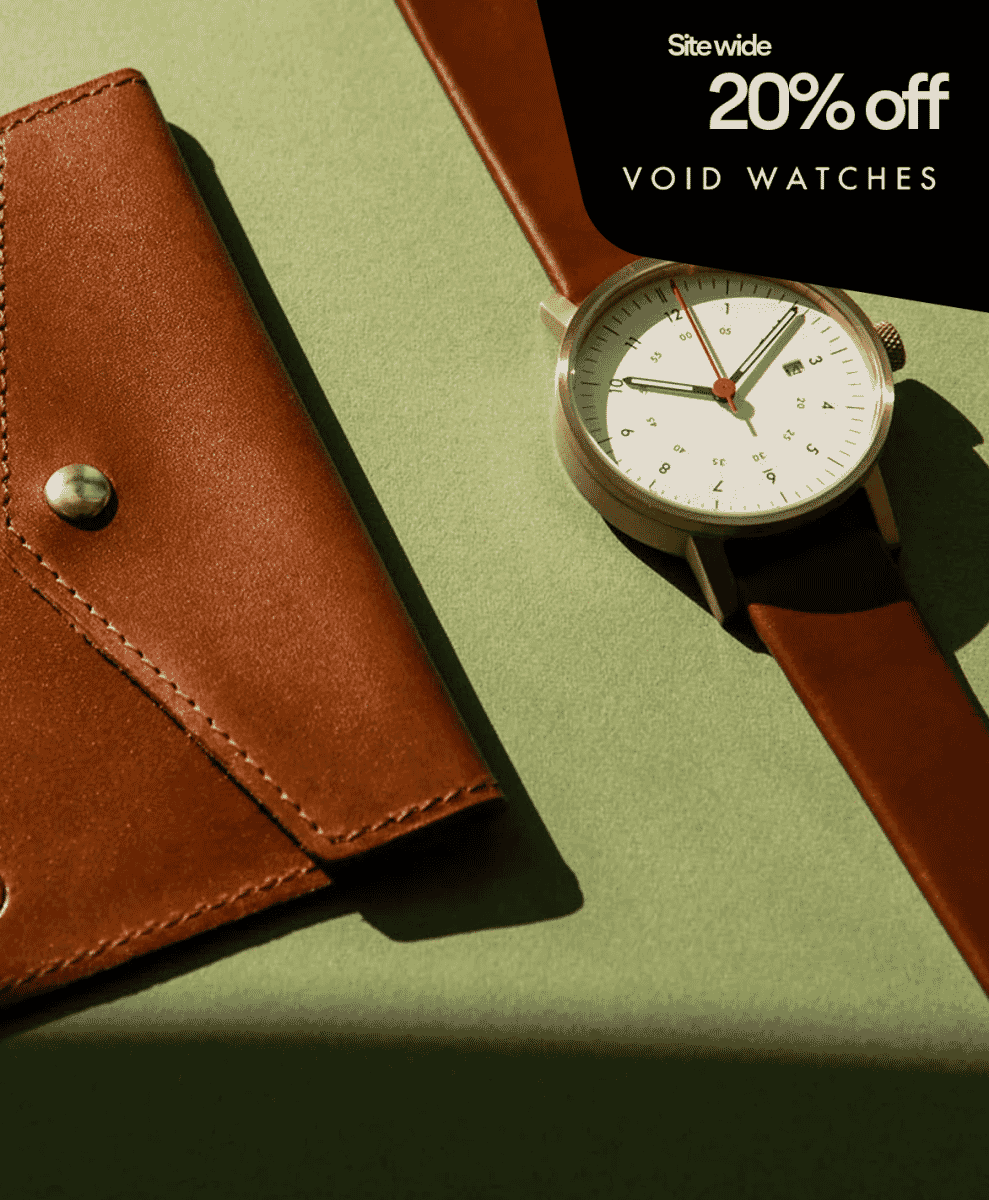 A minimalist wristwatch with a brown leather strap next to a matching wallet.
