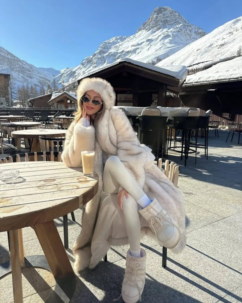 Woman in an all-white ensemble with a fluffy fur coat and matching leggings.