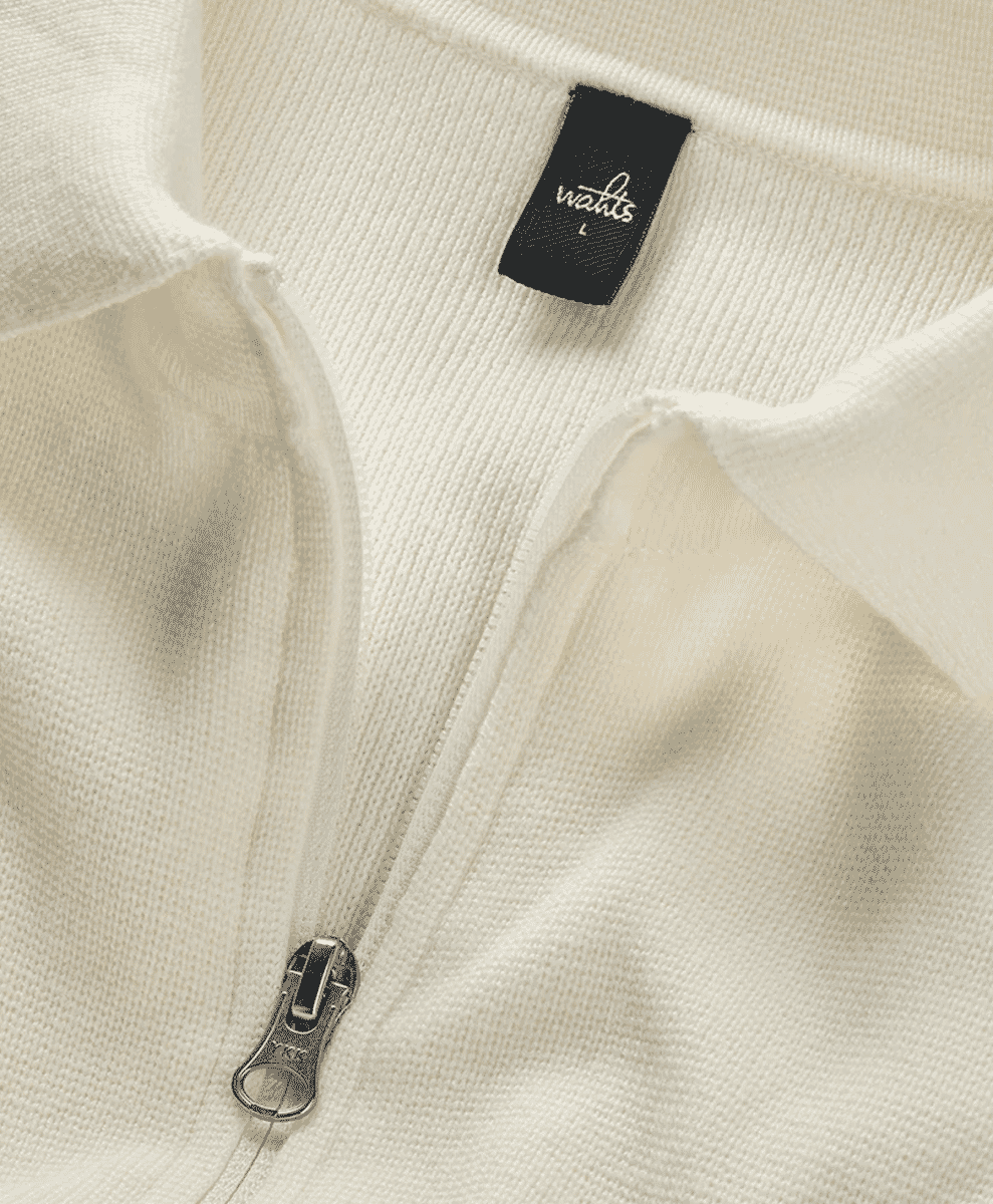Close-up of a cream-colored ribbed knit zip-up sweater from Watts.